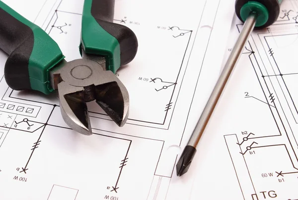 Metal pliers and screwdriver on electrical construction drawing of house — Stockfoto