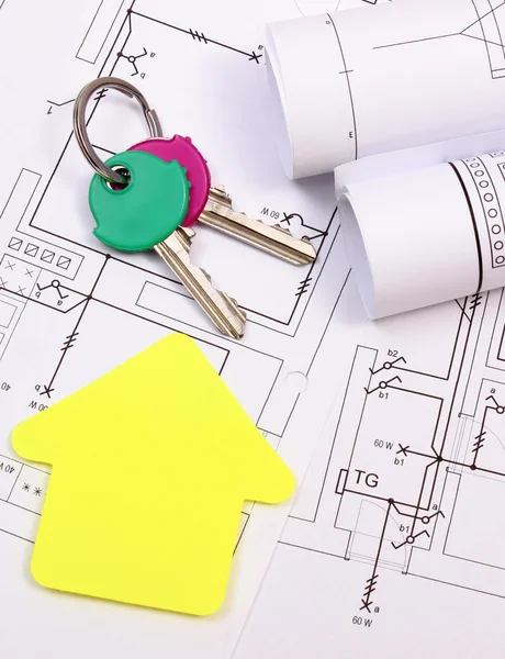 Casa de papel amarillo, llaves de casa, rollos de diagramas sobre dibujo de construcción — Foto de Stock