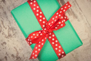 Vintage photo, Green gift for Christmas or other celebration on wooden plank