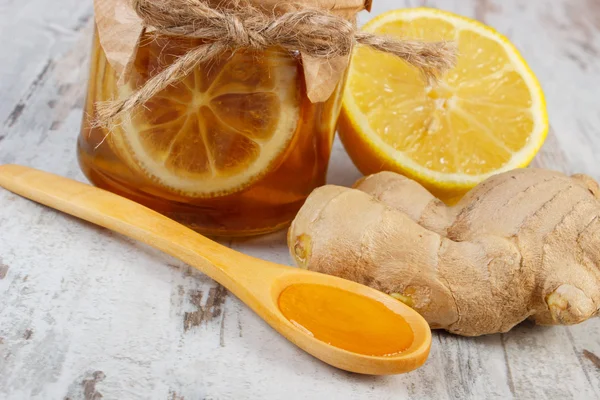 Свежий лимон, мед и имбирь на деревянном столе, здоровое питание — стоковое фото