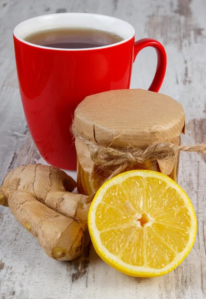 Лимон с медом, имбирь и чашка чая на деревянном столе, здоровое питание — стоковое фото