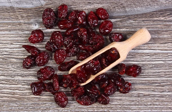 Heap of red cranberries with spoon on wooden table — Stock Photo, Image