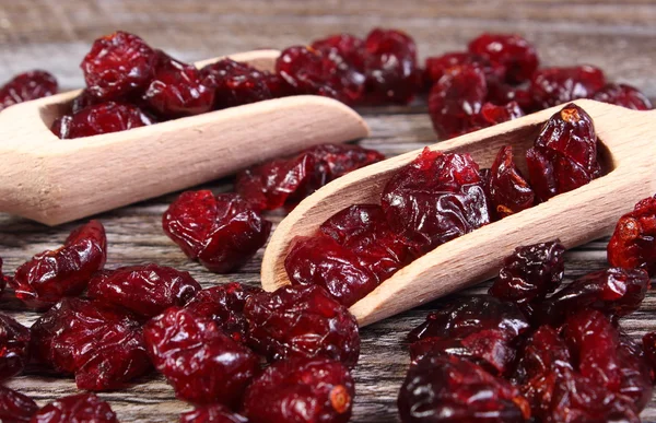Heap of red cranberries with spoon on wooden table — Stock Photo, Image