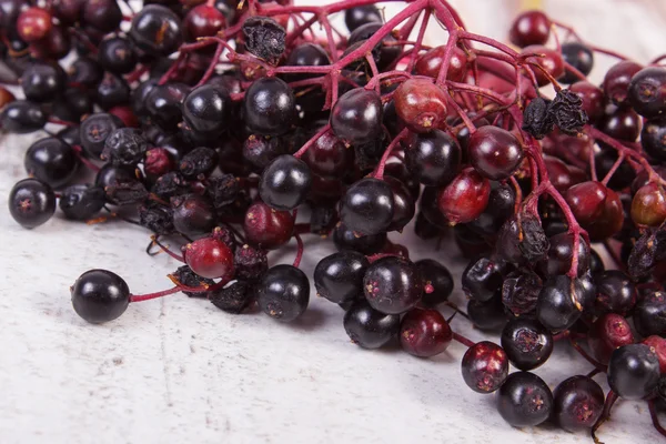 Bunch of fresh elderberry on old wooden background, healthy food — Stock Photo, Image