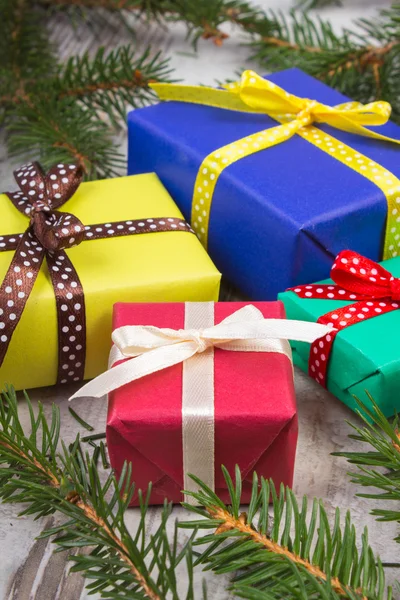 Ingepakte cadeaus voor Kerstmis of andere viering en vuren takken op oude plank — Stockfoto