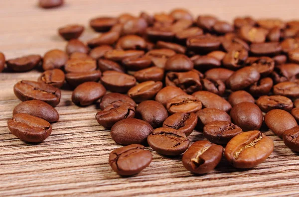 Un mucchio di caffè su sfondo di legno — Foto Stock