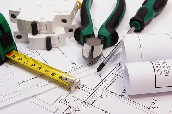 Work tools, electric fuse and rolls of diagrams on construction drawing of house — Stock Photo, Image