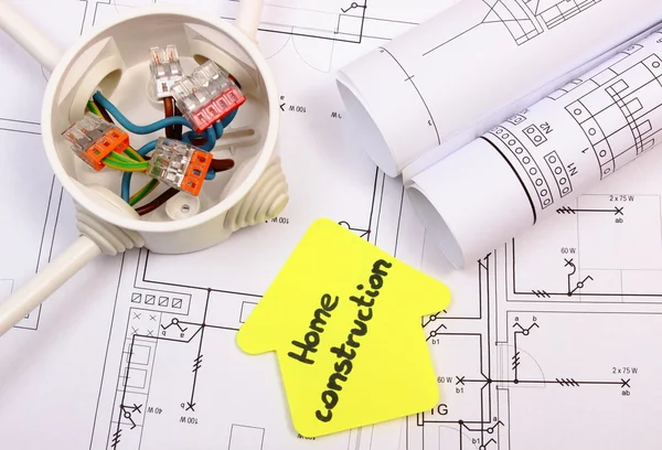 Casa de papel amarillo, caja eléctrica con cables y dibujo de construcción — Foto de Stock