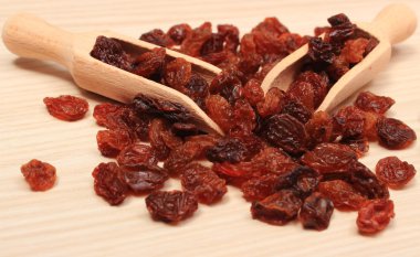Ahşap masa, sağlıklı kaşık ile kahverengi kuru üzüm yemek