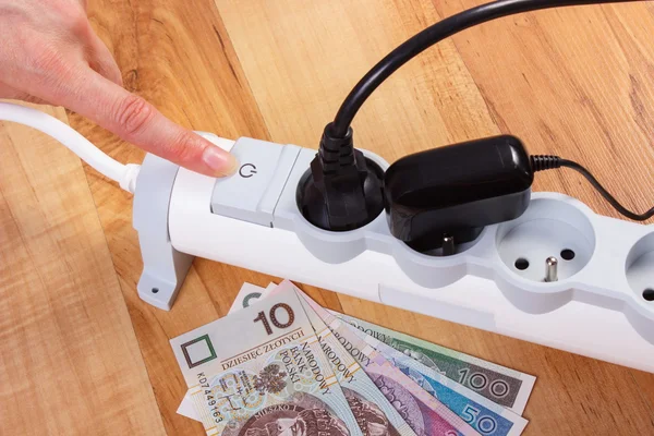 Tira de corriente eléctrica con enchufe conectado y dinero moneda polaco, costos de energía — Foto de Stock