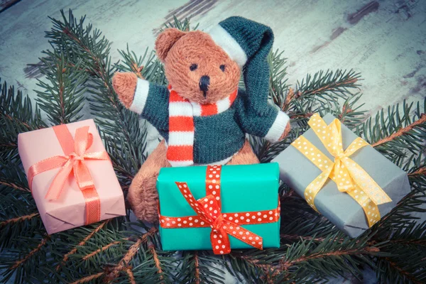 Ročník Foto, medvídek s barevnými dárky na Vánoce a smrkové větve — Stock fotografie
