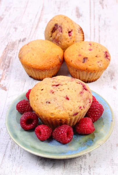 Fresh baked muffins with raspberries on old wooden background, delicious dessert — Stock Photo, Image