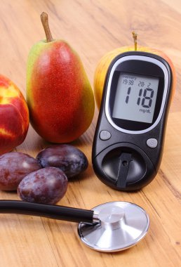 Glucose meter with medical stethoscope and fresh fruits, healthy lifestyle