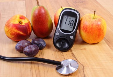 Glucose meter with medical stethoscope and fresh fruits, healthy lifestyle