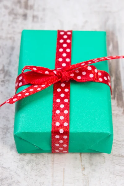 Zielony prezent na Boże Narodzenie lub innych uroczystości na drewniane deski — Zdjęcie stockowe