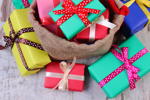 Куча упакованных подарков на Рождество или другой праздник на старой деревянной доске
