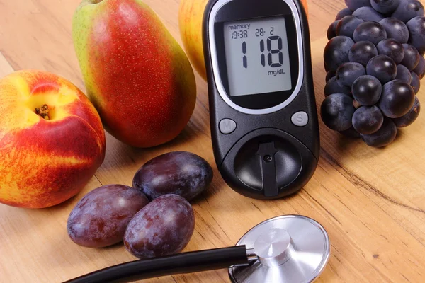 Glucose meter with medical stethoscope and fresh fruits, healthy lifestyle