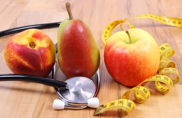 Medical stethoscope with tape measure and fresh fruits, healthy lifestyle — 图库照片