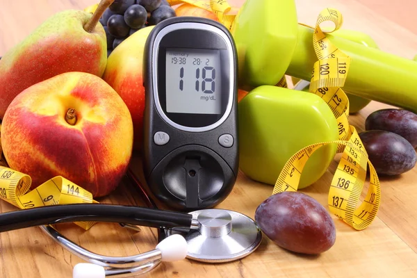 Medidor de glucosa con estetoscopio médico, frutas y pesas para usar en fitness —  Fotos de Stock