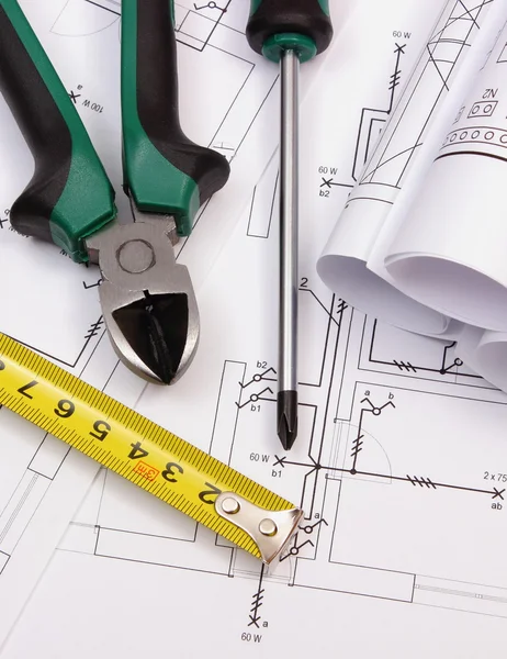 Work tools and rolls of diagrams on construction drawing of house — Stock Photo, Image