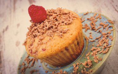 Vintage photo, Baked muffins with raspberries and grated chocolate on wooden background, delicious dessert