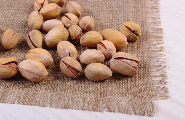 Фисташковые орехи на белом деревянном столе, здоровое питание — стоковое фото