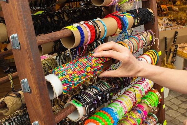 Mão de mulher com pulseiras coloridas na barraca no bazar — Fotografia de Stock