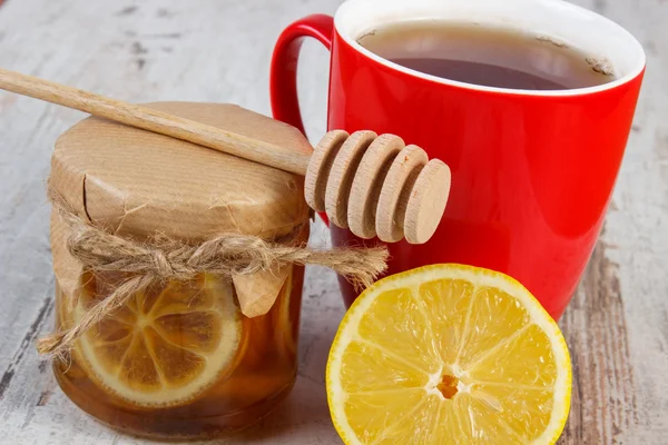 Fresh lemon with honey and cup of tea on wooden table, healthy nutrition — Stock Photo, Image