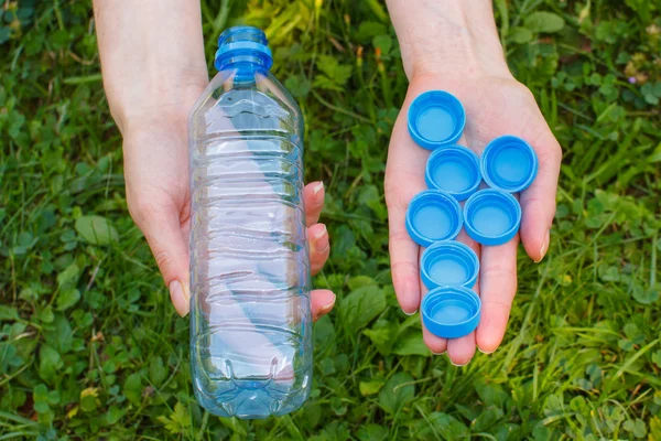 Plastik şişe ve şişe kapakları, kadın ile el çevre çöp