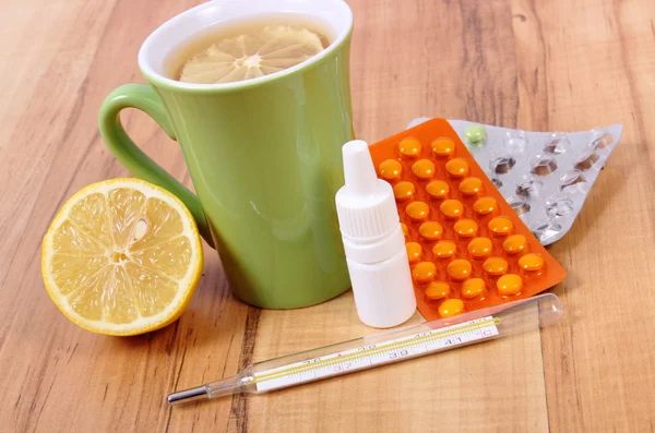 Таблетки, капли носа и горячий чай с лимоном от простуды, лечение гриппа и насморка — стоковое фото