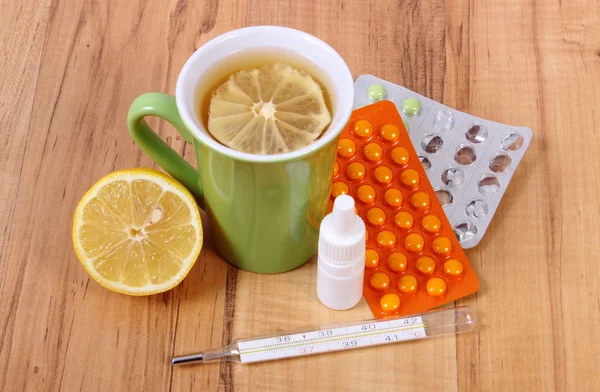 Pastillas, gotas para la nariz y té caliente con limón para los resfriados, tratamiento de la gripe y la secreción — Foto de Stock