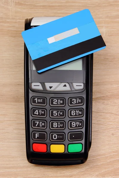 Payment terminal with contactless credit card on desk, finance concept