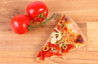 Vejetaryen pizza ve ahşap yüzey üzerinde domates dilim