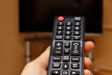 Televizyon için uzaktan kumanda tutan el