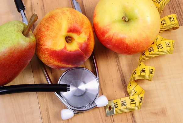 Medical stethoscope with tape measure and fresh fruits, healthy lifestyle — Stock Photo, Image