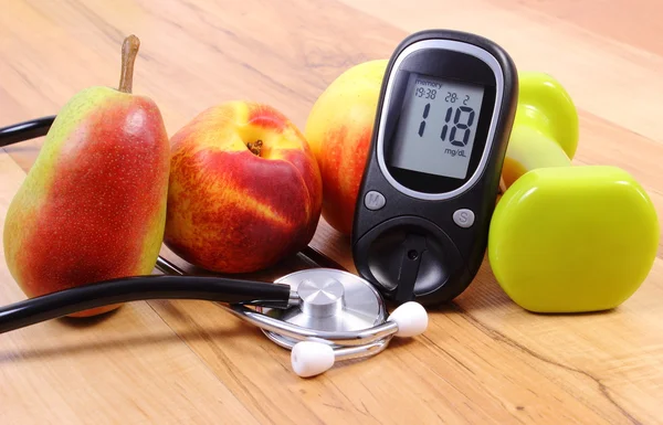 Medidor de glicose com estetoscópio médico, frutas e halteres para uso em fitness — Fotografia de Stock