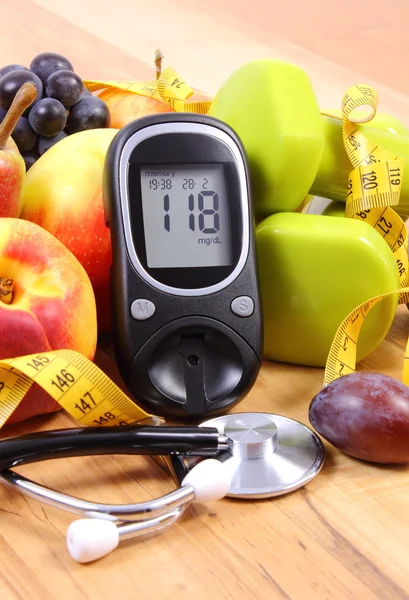 Medidor de glucosa con estetoscopio médico, frutas y pesas para usar en fitness — Foto de Stock