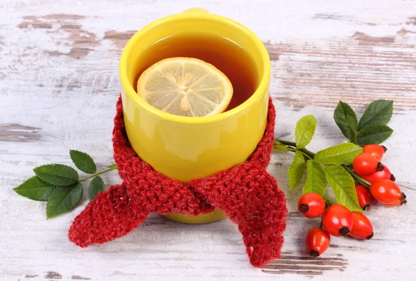 Taza de té con pañuelo de lana envuelto en limón, bebida caliente para la gripe, decoración de otoño — Foto de Stock