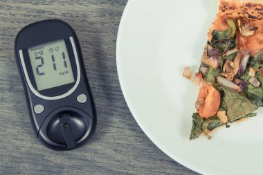 Glikoz ölçer, yüksek şeker seviyesi ve taze pişmiş vejetaryen pizzası sonucu oluşmuş. Diyabet konsepti sırasında besin