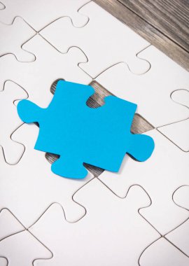 Otizm Spektrum Bozukluğunun sembolü olarak beyaz ve mavi yapboz. Otizm Farkındalık Günü konsepti