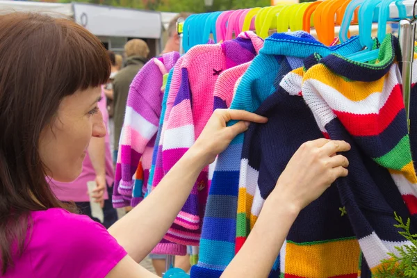 Frau kauft Kleidung auf dem Basar ein — Stockfoto