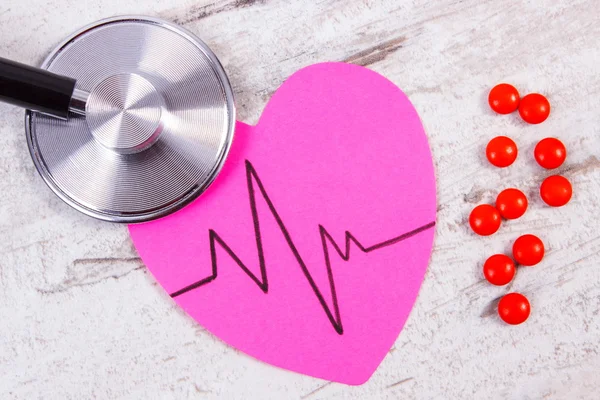 A szív papír cardiogram vonal, sztetoszkóp és kiegészítés pills, orvosi és egészségügyi koncepció — Stock Fotó