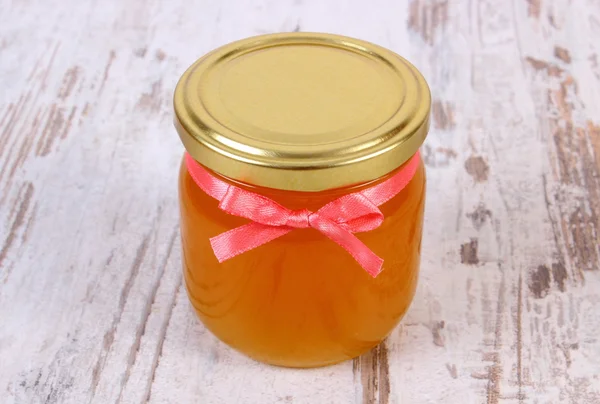 Miel orgánica fresca en frasco de vidrio sobre fondo de madera, nutrición saludable y fortalecimiento de la inmunidad — Foto de Stock