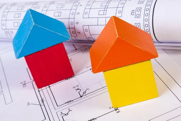 Casas de los bloques de madera y los rollos de los diagramas sobre la construcción el dibujo de la casa — Foto de Stock