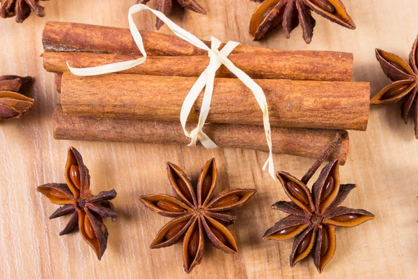 Steranijs en kaneel stokjes op houten tafel, kruiden voor het koken — Stockfoto