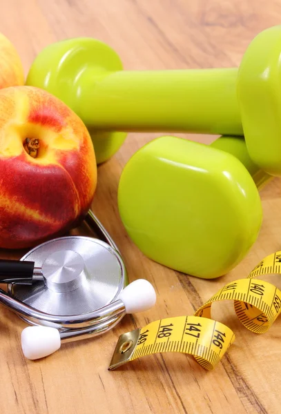 Medical stethoscope, fruits and dumbbells for using in fitness — Stock Photo, Image