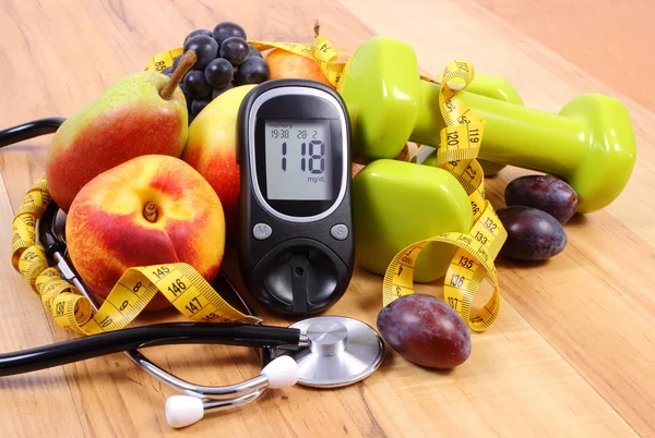 Glucose meter with medical stethoscope, fruits and dumbbells for using in fitness — Stock Photo, Image