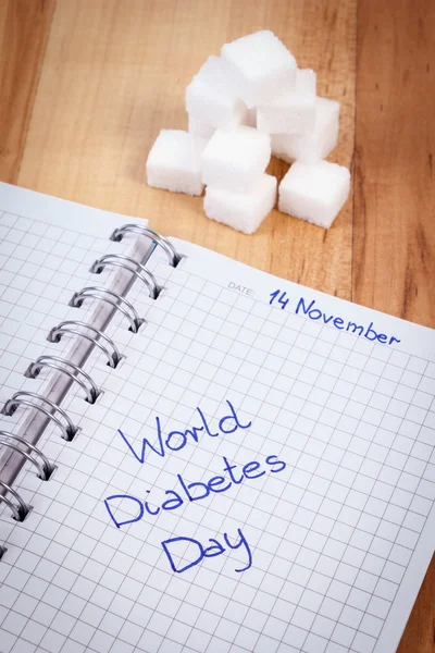 Επιγραφή παγκόσμια ημέρα διαβήτη στο σημειωματάριο και ζάχαρη κύβους, σύμβολο των διαβητικών — Φωτογραφία Αρχείου