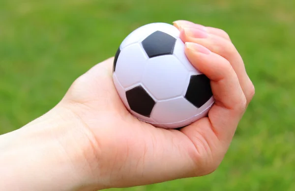 Kleiner Stressball in der Hand auf Gras Hintergrund — Stockfoto