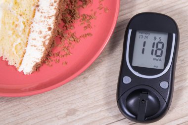Glikoz ölçer, yüksek şeker seviyesi ve katmanlı ve çikolatalı tatlı pasta sonucu oluşur. Diyabet konsepti sırasında besin